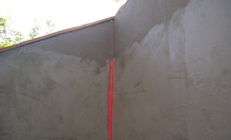 Obložení venkovní betonové stěny úmělým kamenem + vydláždění prostoru u stěny 