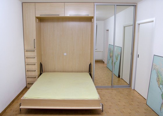 Kuchyňská linka a úložná skříň s vyklápěcí postelí a sedačkou